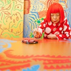 TOKYO, JAPAN - JANUARY 25:  Japanese artist Yayoi Kusama sits working on a new painting, in front of other newly finished paintings in her studio, on January 25, 2012 in Tokyo, Japan. Yayoi Kusama, who suffers from mental health problems and lives in a hospital near her studio, is one of today's most highly revered and popular of Japanese artists. She is one of the world's top selling living female artists breaking records in the millions. A major retrospective of her work is on display at Tate Modern in London through June 5, 2012.  (Photo by Jeremy Sutton-Hibbert/Getty Images)